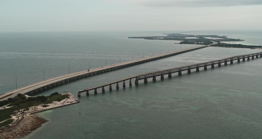 Aerial view of vehicles driving on a bridge over islands in the ocean