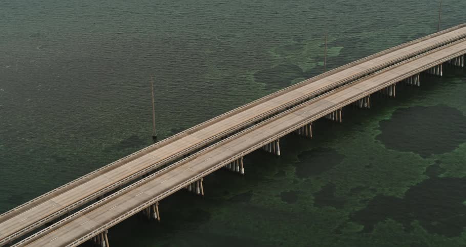 Aerial view of cars traveling across a long bridge over water