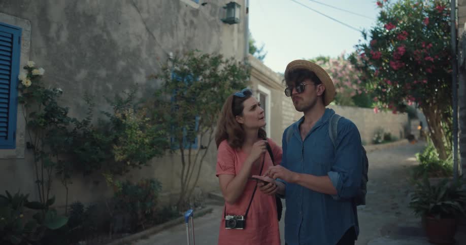 Couple stand in road near suitcase consulting mobile phone for navigation
