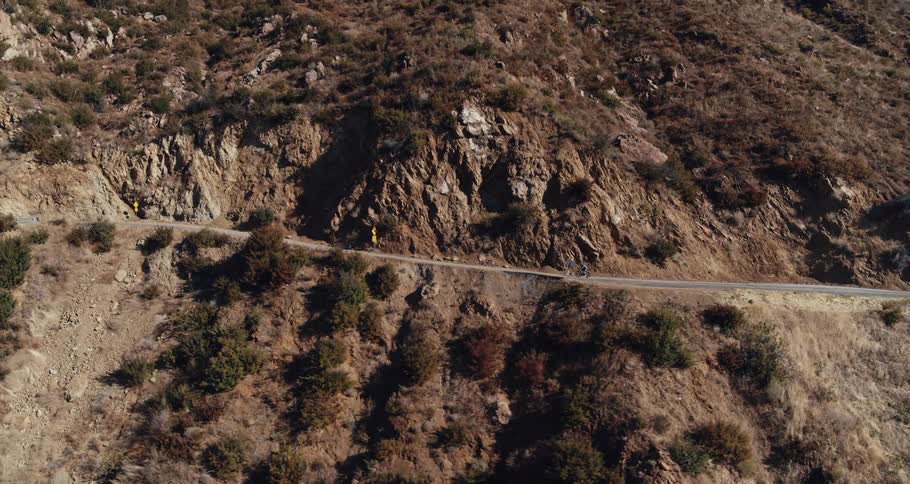 An aerial view of a bicycle riding up a mountain road