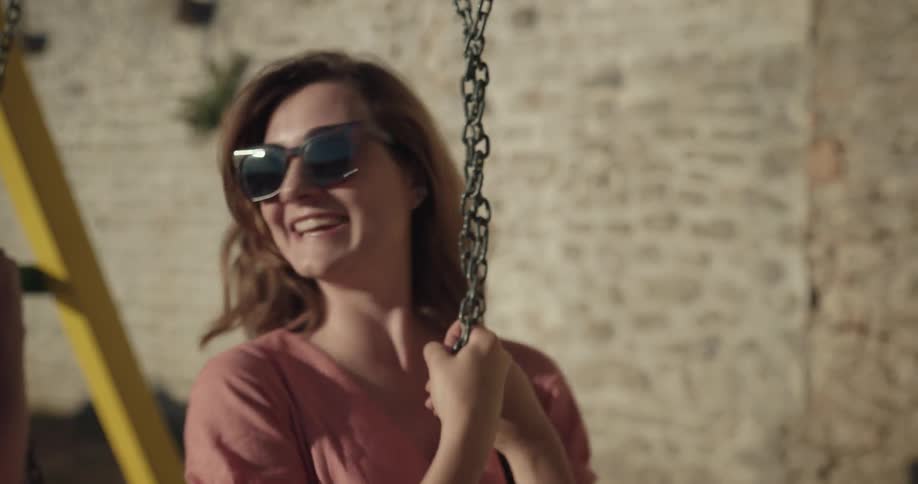 Young happy traveling couple playing on swings in the morning