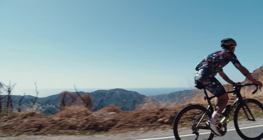 Two cyclists climbing a mountain road at daytime