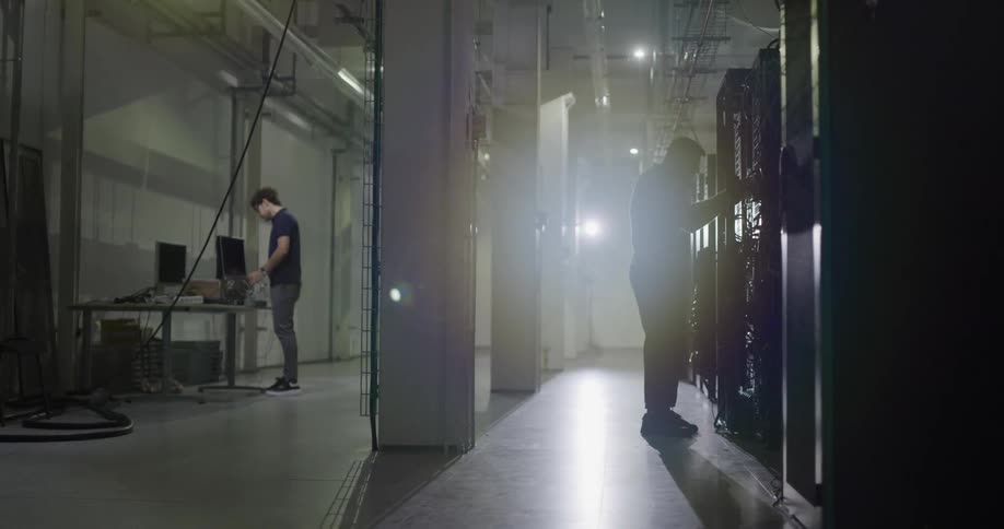 Technicians working on a big server room inside a warehouse