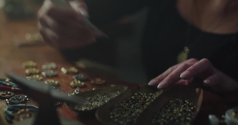 A jewelry maker is picking beads from a bunch