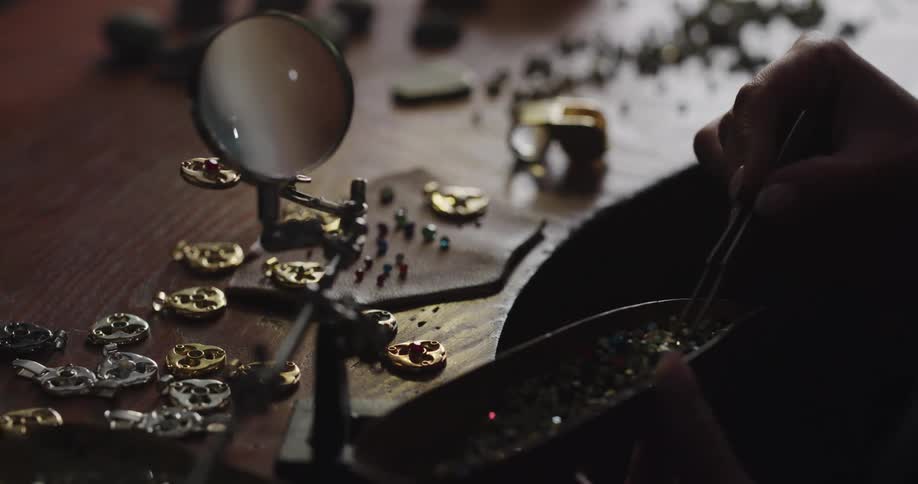 A person is checking beads under the magnifying glass