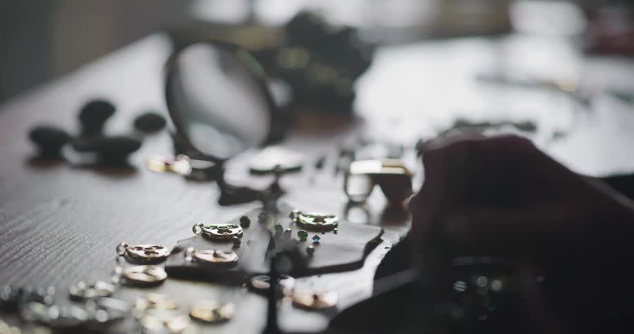 Woman working inside a dimly lit workshop handcrafting jewelry