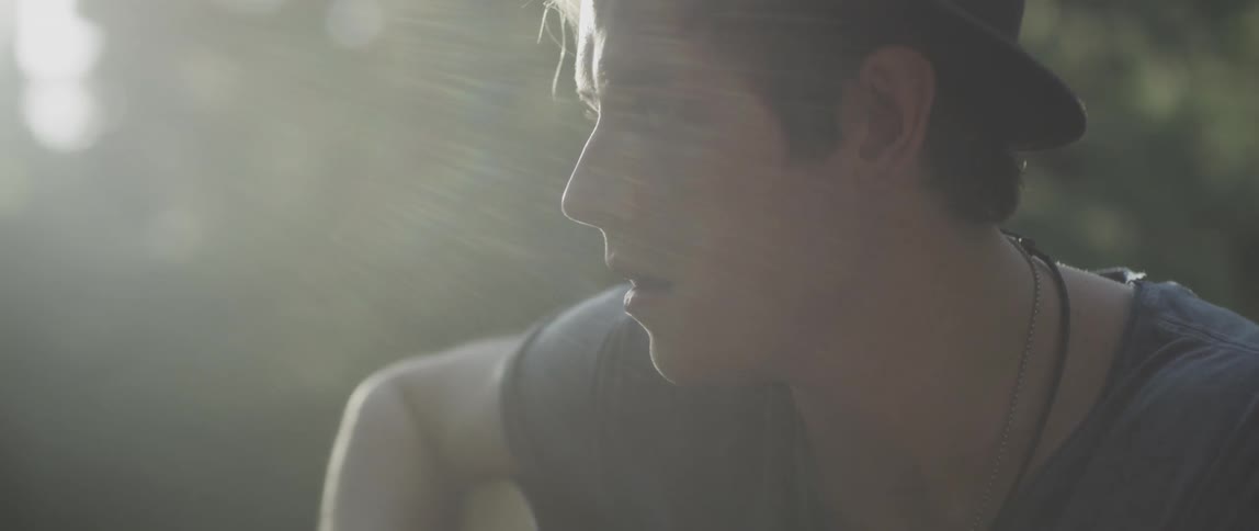 A man looks down while playing a guitar