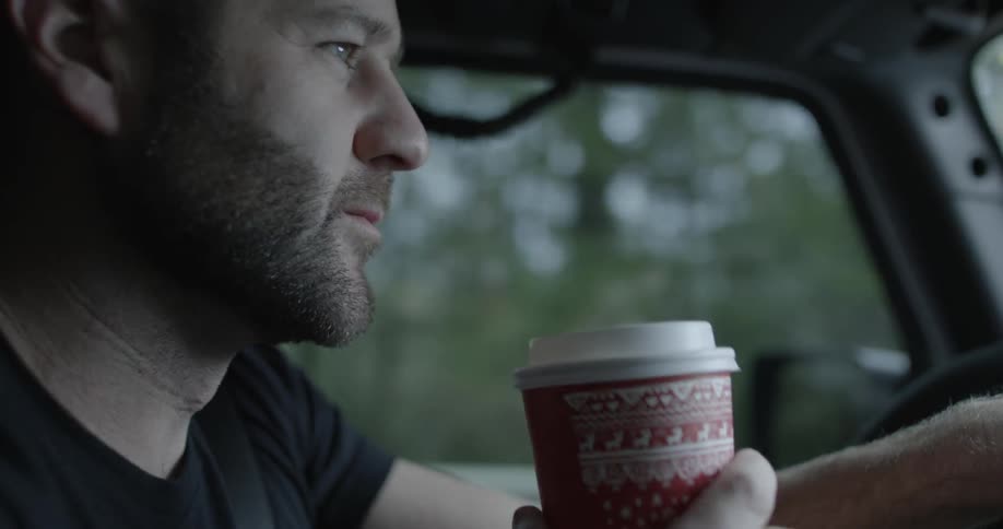 Man drinking from a cup while driving