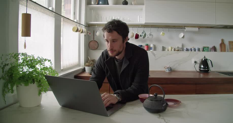 A man that is typing on a laptop in a building