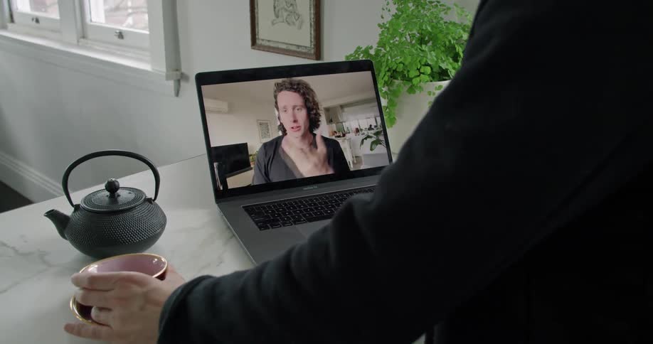 Two people enjoying hot beverages while talking over video chat