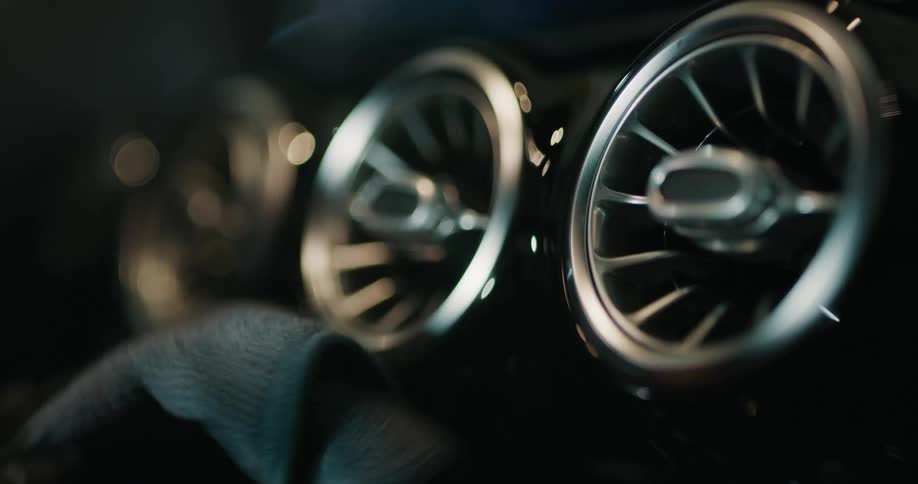 A man brushes and wipes the interior of a car