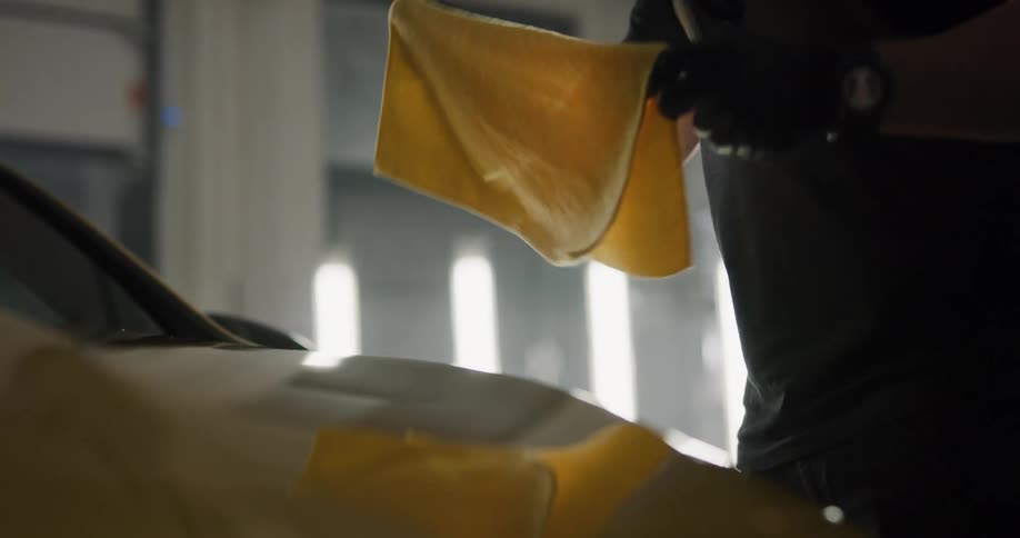 A person is polishing a vehicle inside