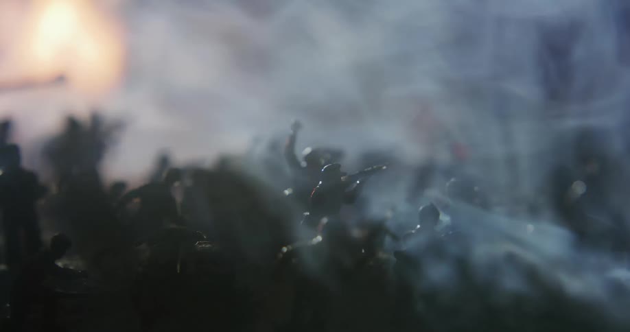 Smoke billows around a battle scene of army men toys
