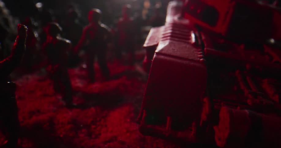 A flashing light shines over toy soldiers arranged in rows near a tank