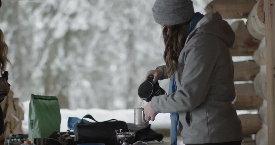A woman pours hot water into a mug