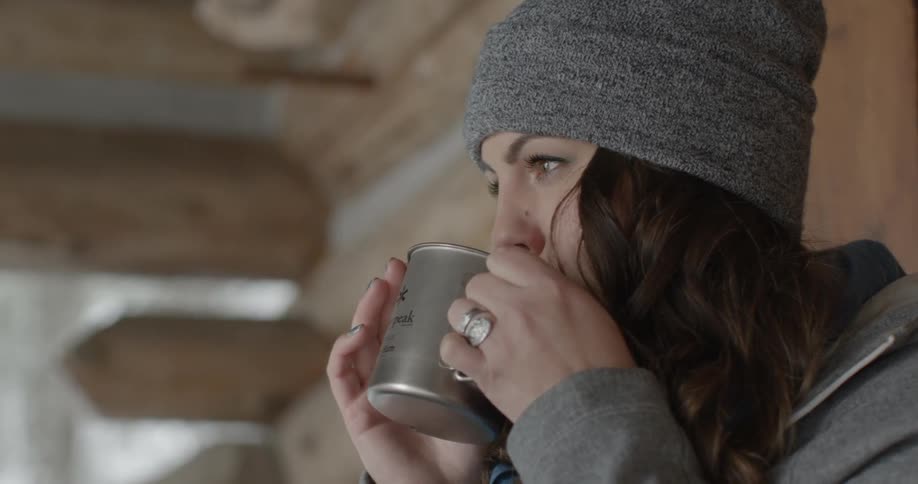A woman drinks from a mug