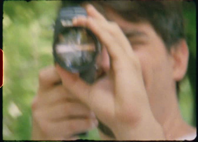 Man filming with a vintage camera caught on vintage film