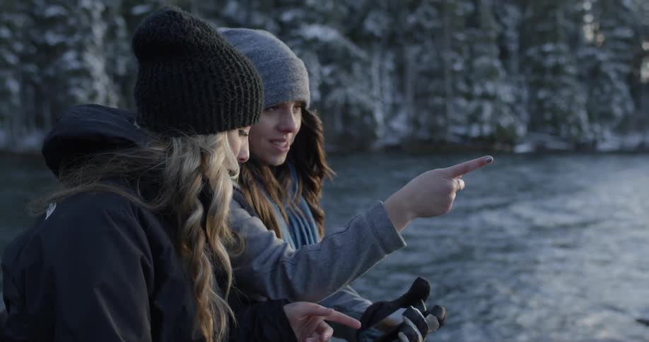 Two women take a selfie in a snowy and forested area