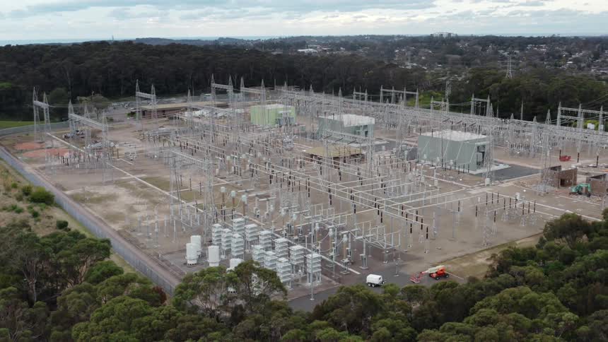 Electrical substation surrounded by trees on the outskirts of a small town