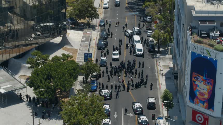 Police officers for circle in center of street with police cars parked nearby