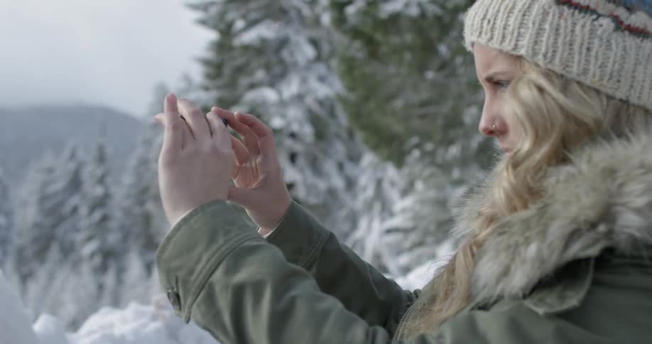 A woman takes pictures of the snowy nature