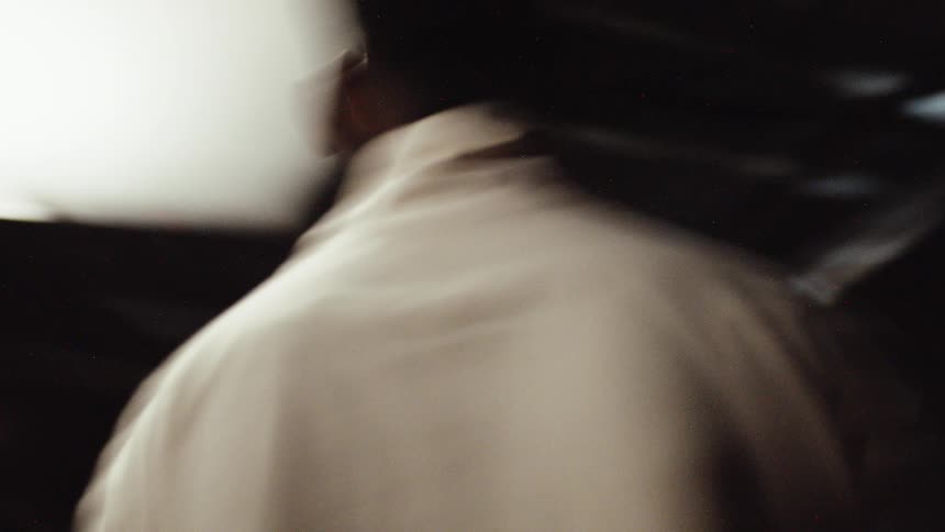 A man is spinning around a room and wearing sunglasses