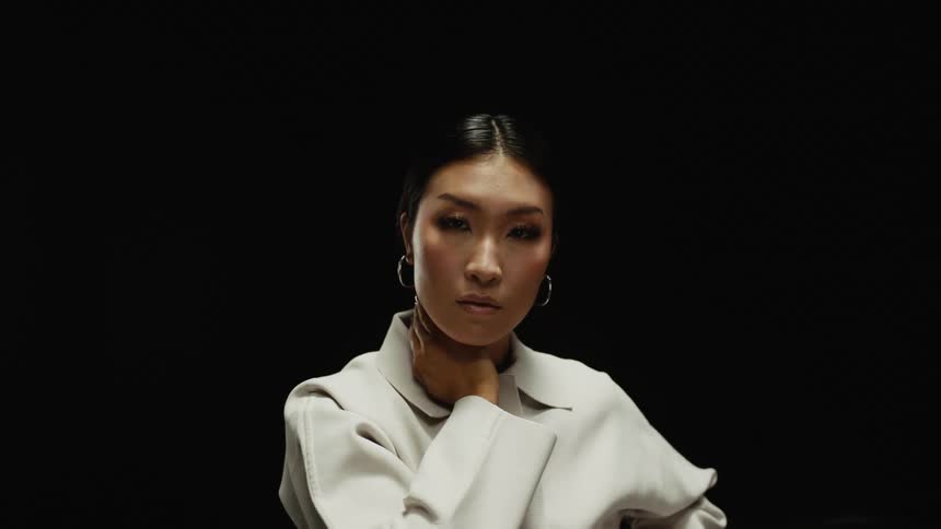 A woman is standing in a room and wearing a jacket