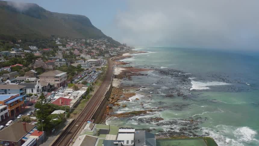 Aerial view of a coastal waterfront town at the foot of a mountain range