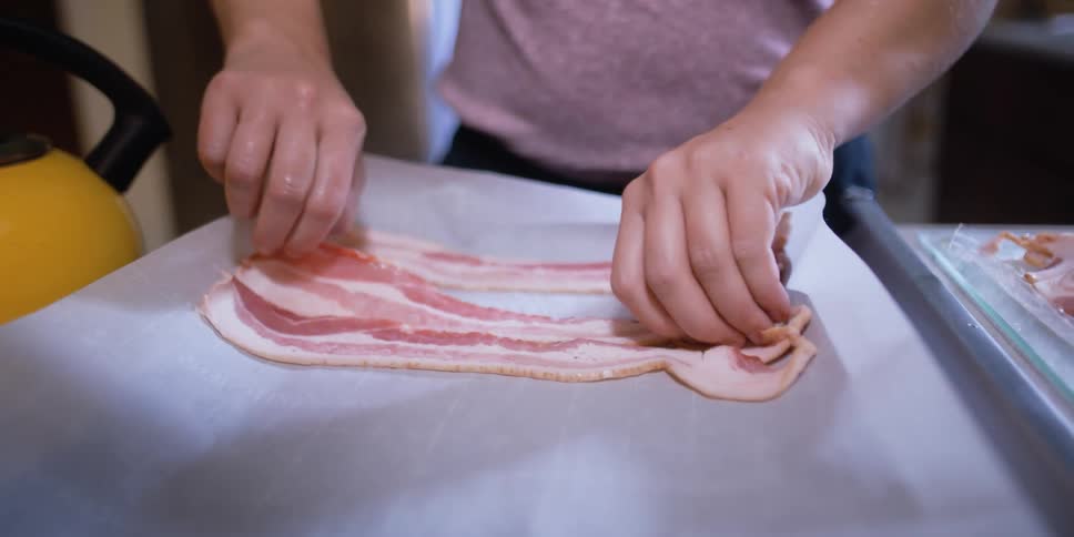 Human preparing bacon