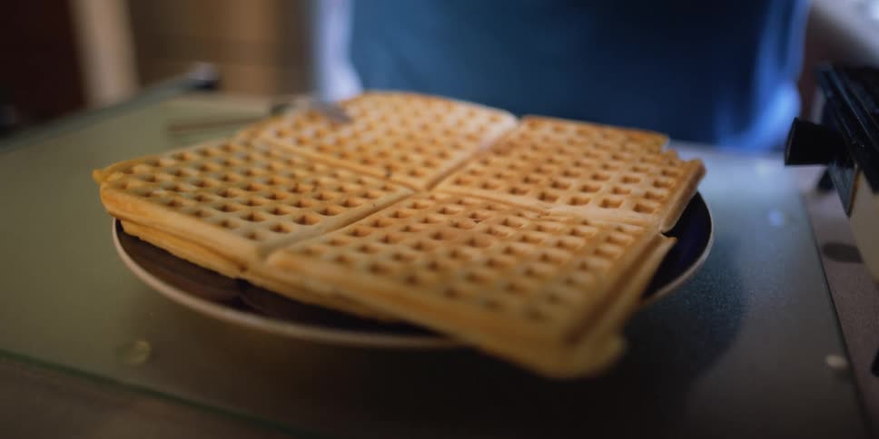 A person is cooking waffles for breakfast in their kitchen