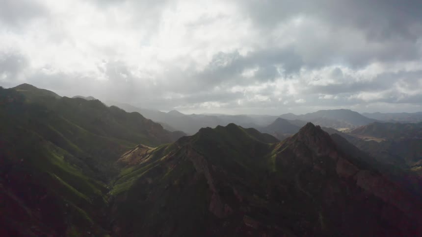 Mountains with peaks high in a cloud filled sky