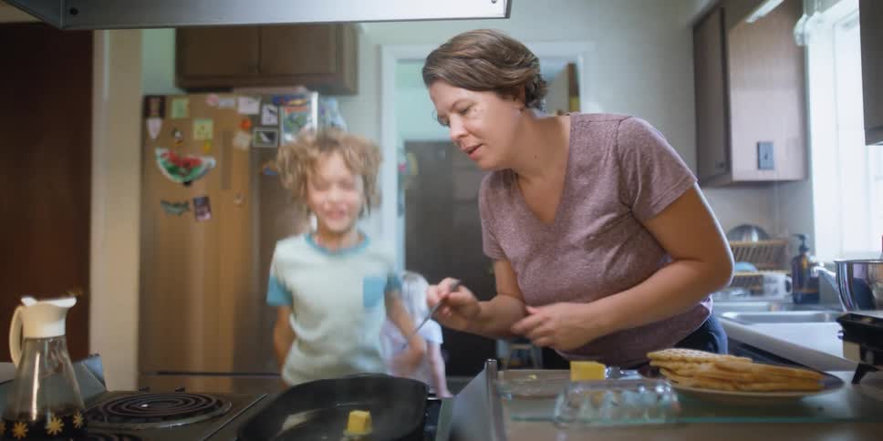 A woman cooking food in a kitchen