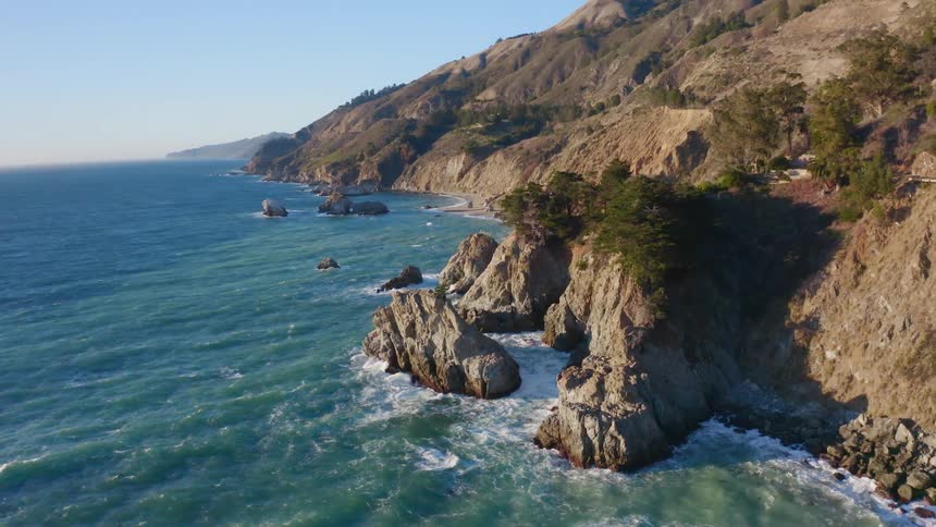 Aerial view of mountains next to an ocean is displayed