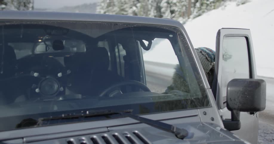 A woman gets into a jeep