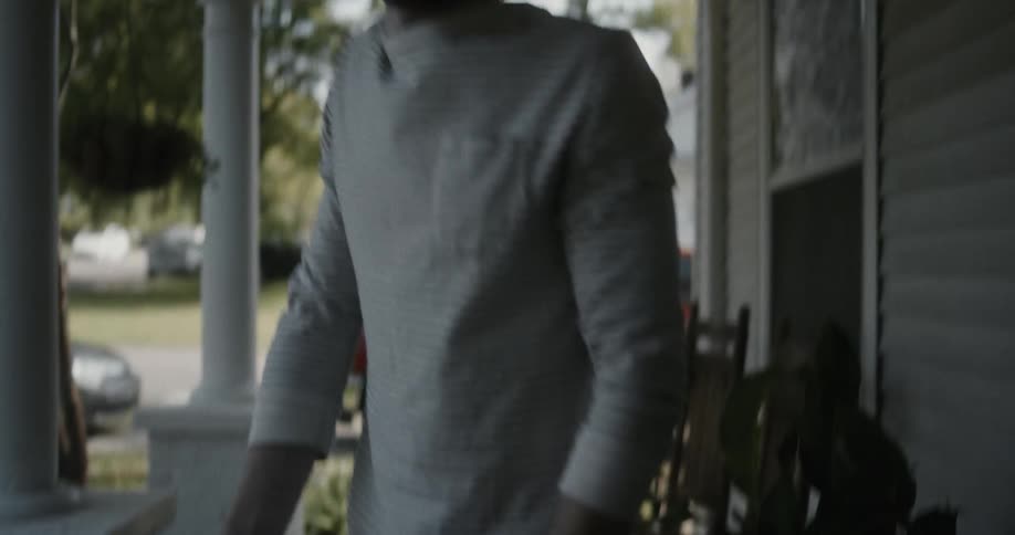 A man picks up a package delivery on his porch