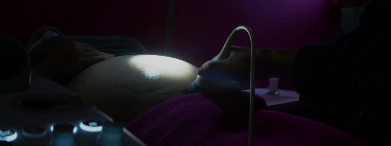 A nurse conducts an ultrasound on a pregnant woman