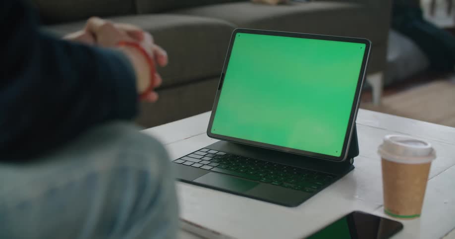 A man is sitting and looking at a laptop