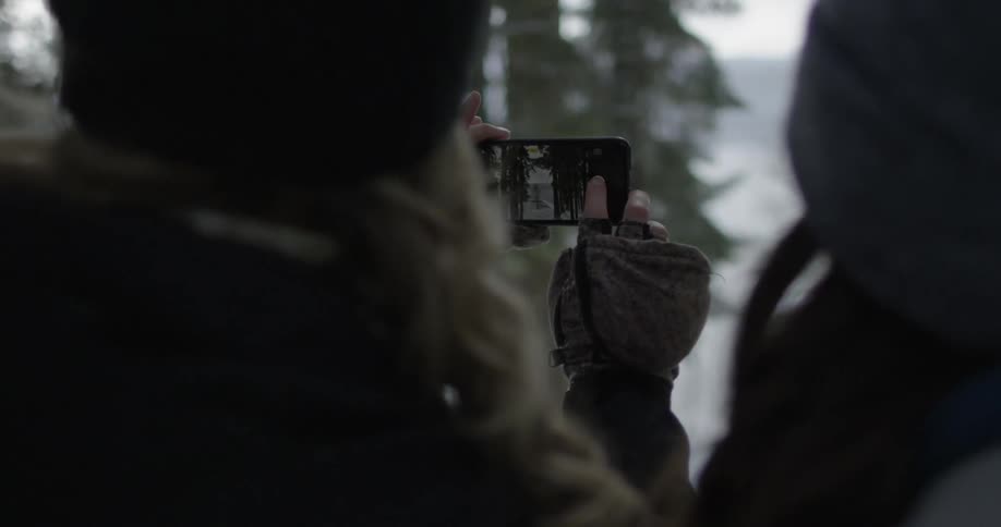 A person takes pictures of a snowy forest