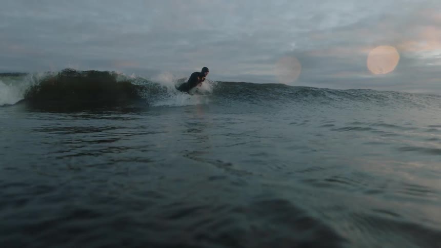 A person surfs the waves