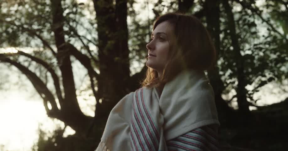 A man and woman are outdoors in the wilderness at dusk