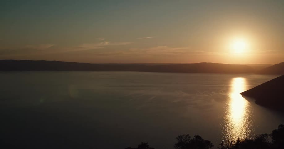 Sunset reflecting over water in a bay and a few clouds in the sky