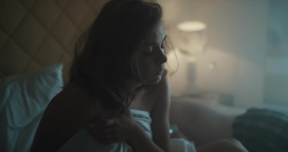 A woman and man are on a bed together and the man is sleeping