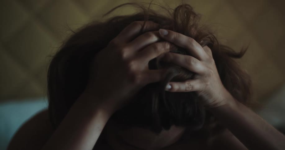 A woman looking stressed while shes in bed