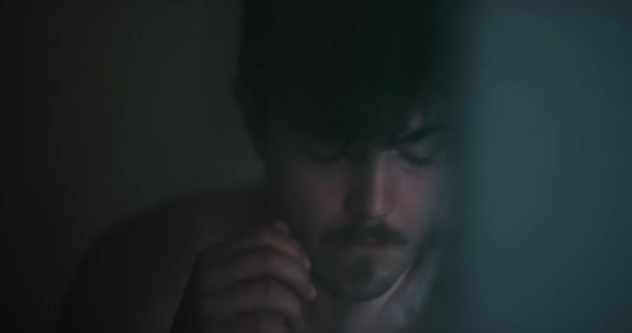 Tired man wakes up and drinks water from a plastic bottle