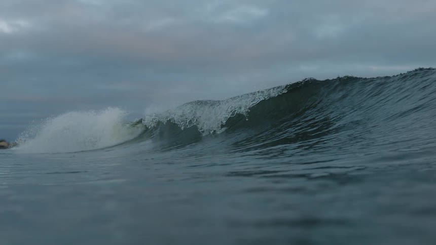 A large wave forms and drops in the water