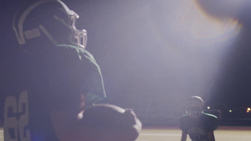 A youth football team practices in the evening