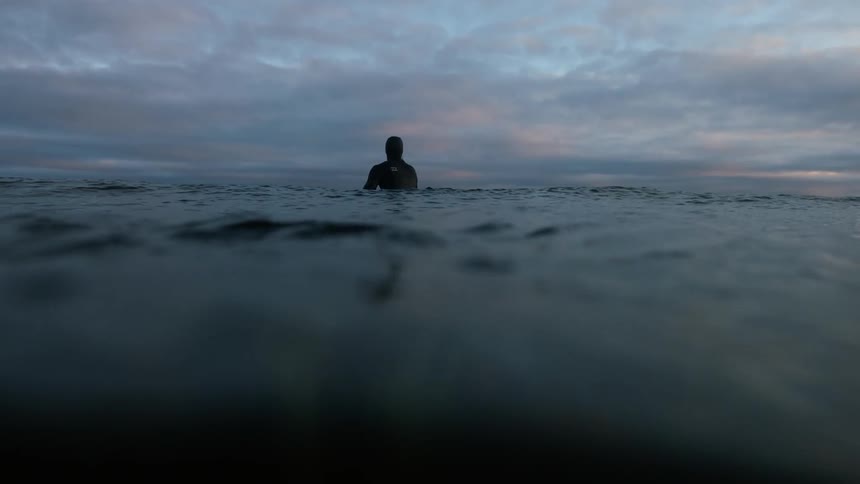 Eye level of rough water with a man floating in it