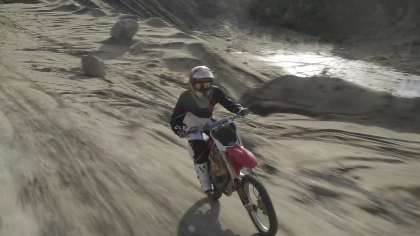 A person on a dirt bike on a dirt trail