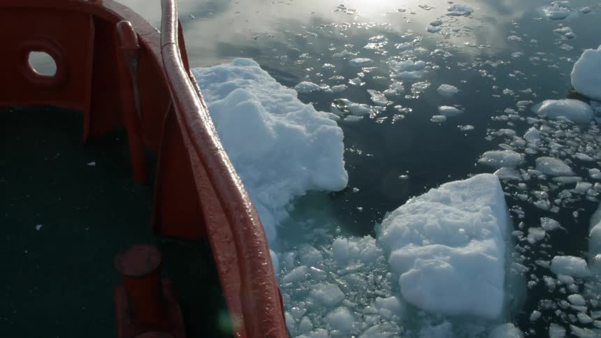 A boat cuts through icy water