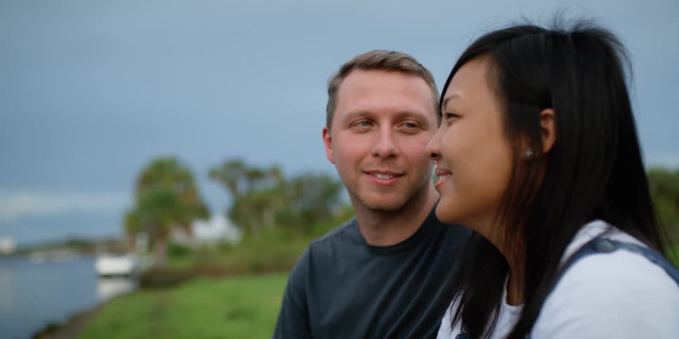 Man and woman talking and laughing by a lake
